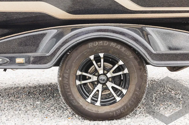 Slide: The Image of 2009 Skeeter ZX 200 boat trailer wheel on gravel. - 25