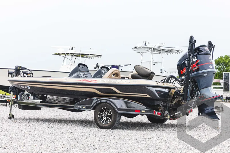 Slide: The Image of 2009 Skeeter ZX 200 bass boat on a trailer in a gravel lot. - 8