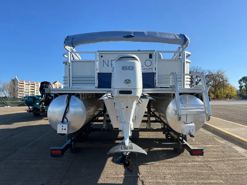 Slide: The Image of 2022 Nepallo CW18 pontoon boat with outboard motor, parked on a sunny day. - 15