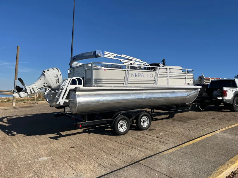 Slide: The Image of 2022 Nepallo CW18 pontoon boat on trailer, parked outdoors under clear blue sky. - 19