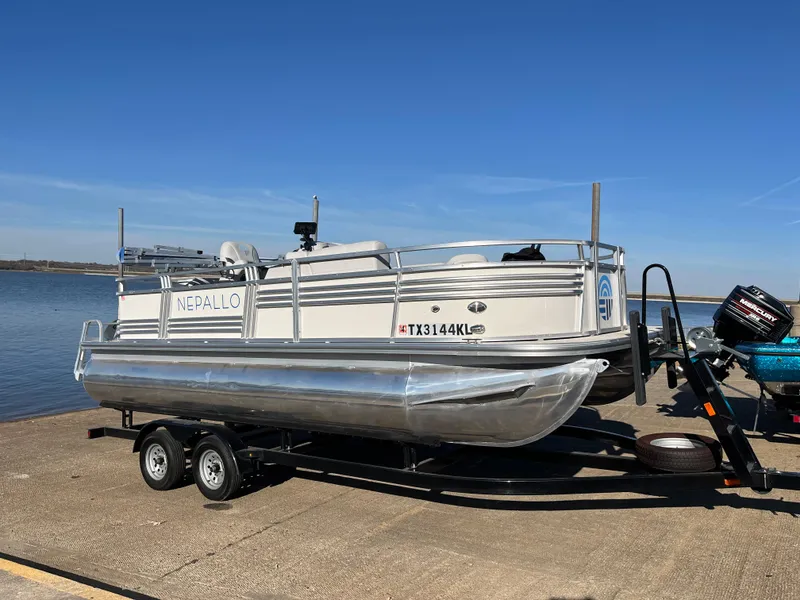 Slide: The Image of Nepallo CW18 2022 pontoon boat on trailer by the water. - 21