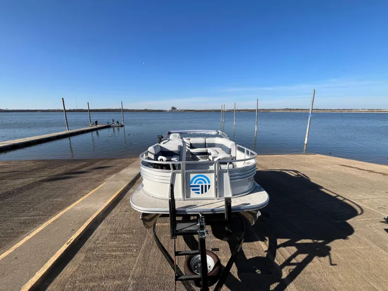 Slide: The Image of Nepallo CW18 boat on trailer by a serene lake, clear blue sky, 2022 model. - 25