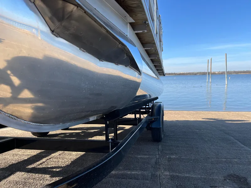 Slide: The Image of Nepallo CW18 pontoon boat on trailer by a lake, 2022 model. - 3