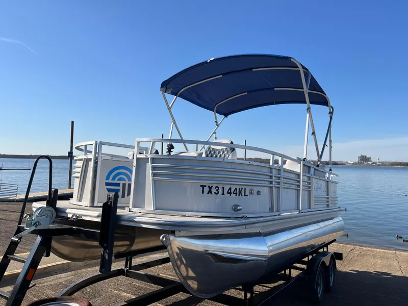 Slide: The Image of 2022 Nepallo CW18 pontoon boat with blue canopy on trailer by the water. - 31