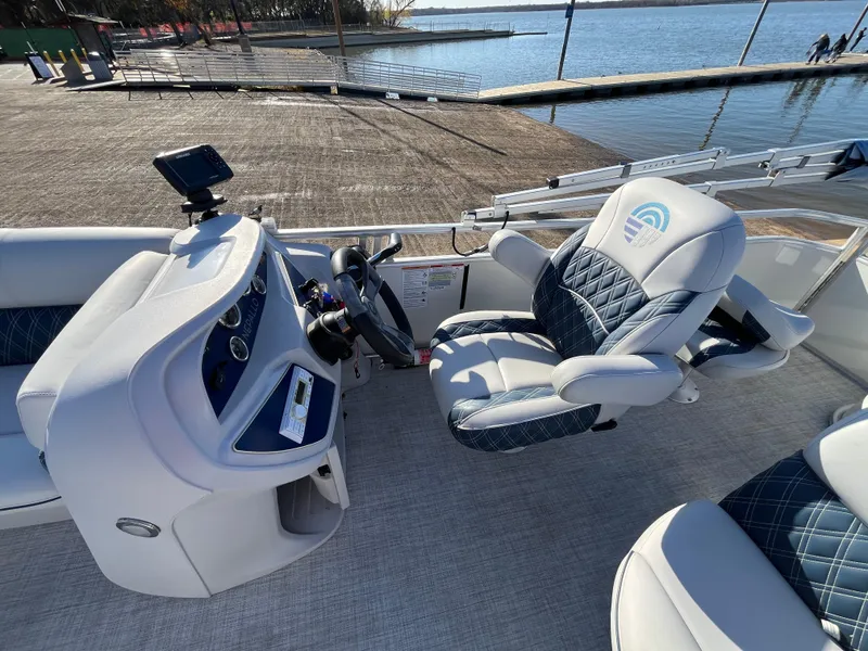 Slide: The Image of Nepallo CW18 2022 boat interior with steering console and cushioned seating by the water. - 37