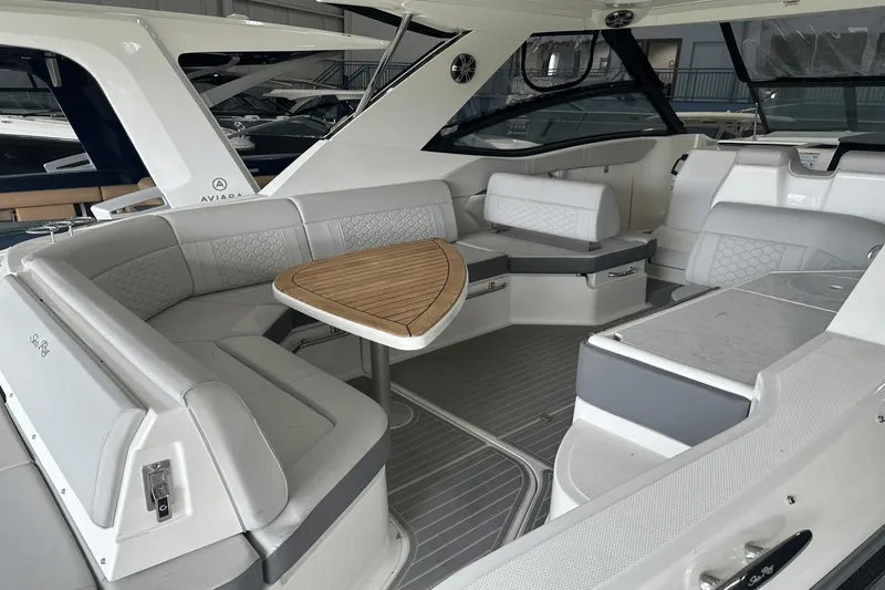 Slide: The Image of 2025 Sea Ray Sundancer 320 interior with elegant seating and wooden table. - 11