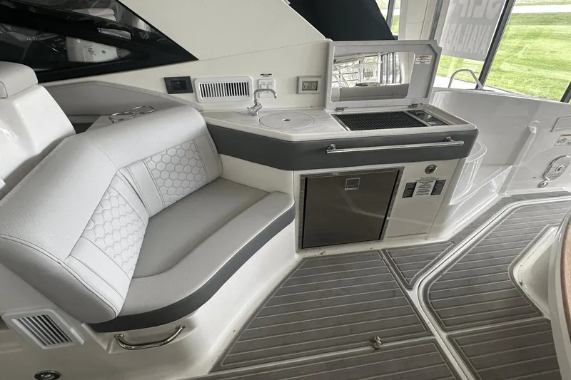Slide: The Image of 2025 Sea Ray Sundancer 320 interior with seating, sink, and grill area. - 14