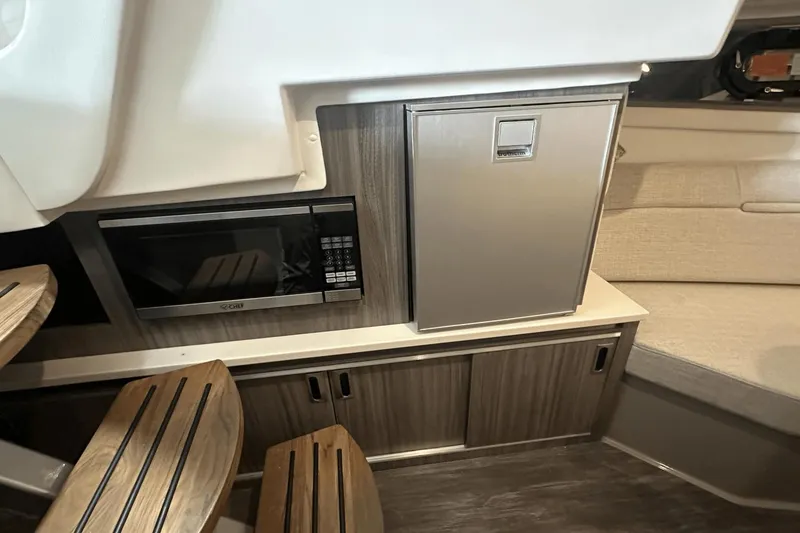Slide: The Image of 2025 Sea Ray Sundancer 320 interior with microwave and compact fridge. - 20
