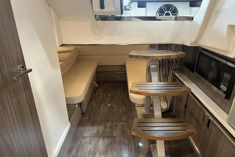 Slide: The Image of 2025 Sea Ray Sundancer 320 interior with modern wood finishes and compact kitchen area. - 21