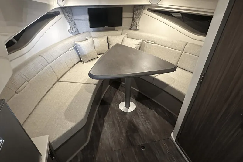 Slide: The Image of 2025 Sea Ray Sundancer 320 interior with cozy seating and modern table. - 23