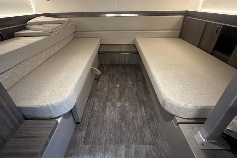 Slide: The Image of 2025 Sea Ray Sundancer 320 cabin interior with modern seating and wood flooring. - 24