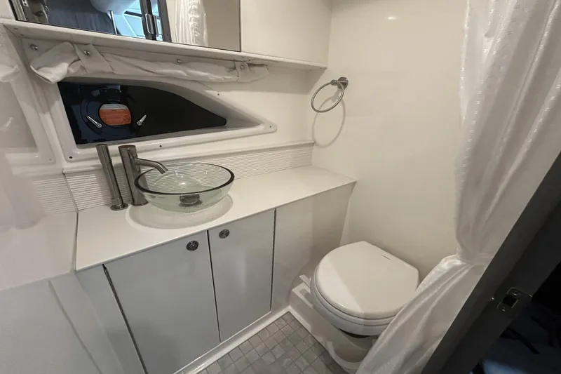 Slide: The Image of 2025 Sea Ray Sundancer 320 bathroom with modern sink, toilet, and window. - 25