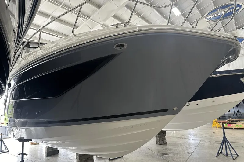 Slide: The Image of 2025 Sea Ray Sundancer 320 yacht in indoor storage, showcasing sleek hull design. - 3