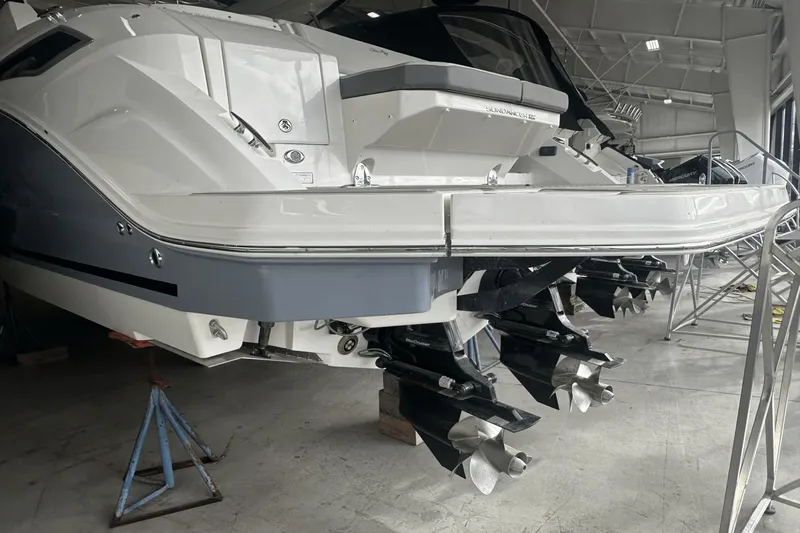 Slide: The Image of 2025 Sea Ray Sundancer 320 boat in showroom, showcasing dual propellers and sleek design. - 4