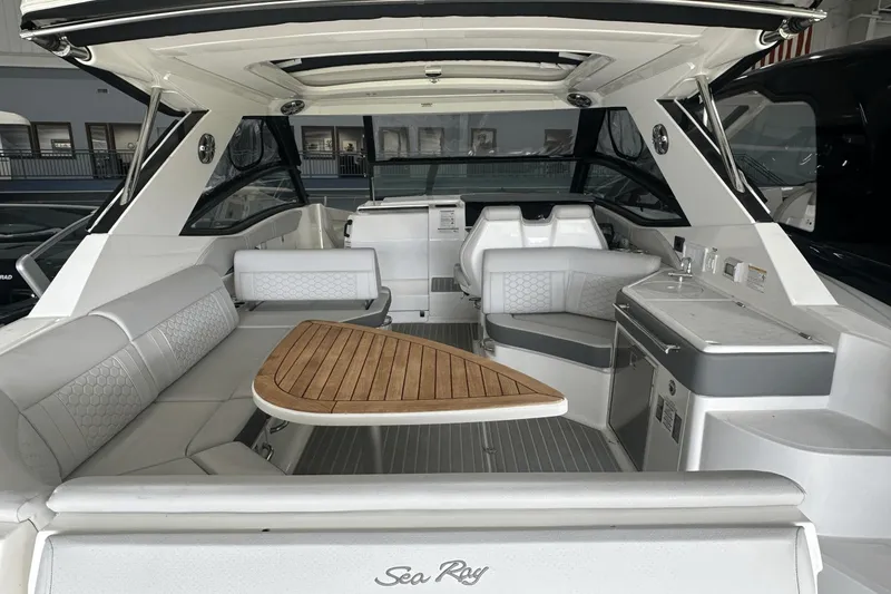 Slide: The Image of 2025 Sea Ray Sundancer 320 interior with sleek seating and wooden table. - 8