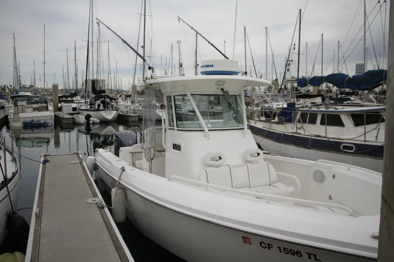 Slide: The Image of 2008 Everglades 270 Center Console boat docked in a marina with other vessels. - 10