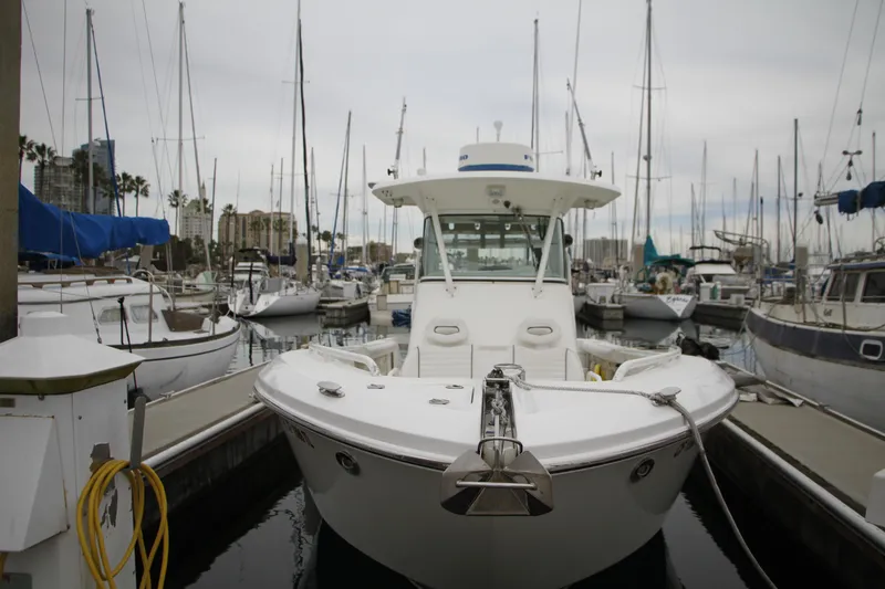 Slide: The Image of 2008 Everglades 270 Center Console boat docked in a marina with sailboats. - 11