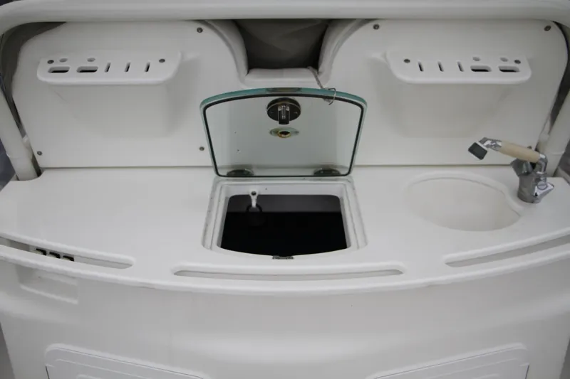 Slide: The Image of 2008 Everglades 270 Center Console boat interior with storage compartments and sink. - 23