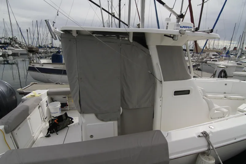 Slide: The Image of 2008 Everglades 270 Center Console boat docked at marina with covered cabin area. - 26