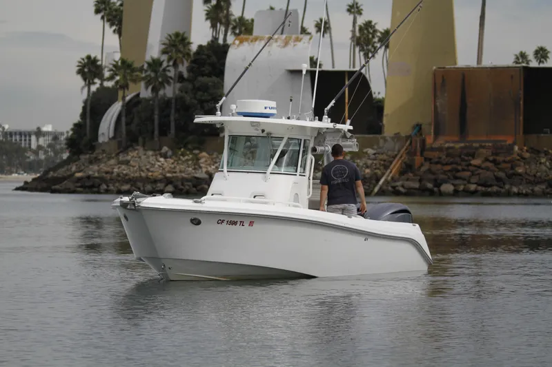 Slide: The Image of 2008 Everglades 270 Center Console boat on calm water near a rocky shoreline. - 5