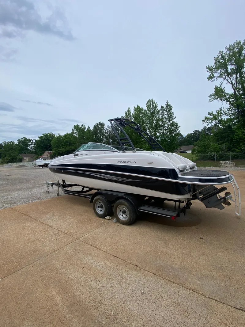 Slide: The Image of 2008 Four Winns F Series F244 boat on a trailer in a parking lot. - 4