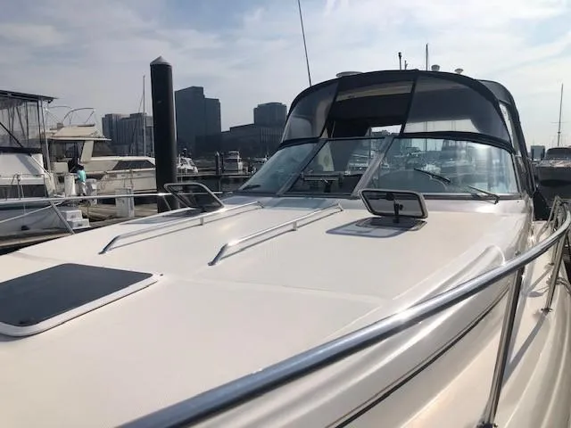 Slide: The Image of 2001 Sea Ray 340 Sundancer docked at marina, city skyline in background. - 22