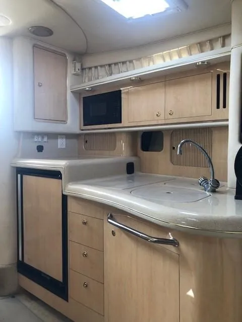 Slide: The Image of 2001 Sea Ray 340 Sundancer yacht kitchen with wood cabinets and modern appliances. - 23