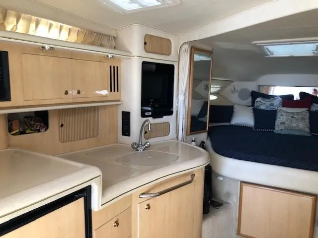 Slide: The Image of Interior of 2001 Sea Ray 340 Sundancer with kitchenette and cozy sleeping area. - 9