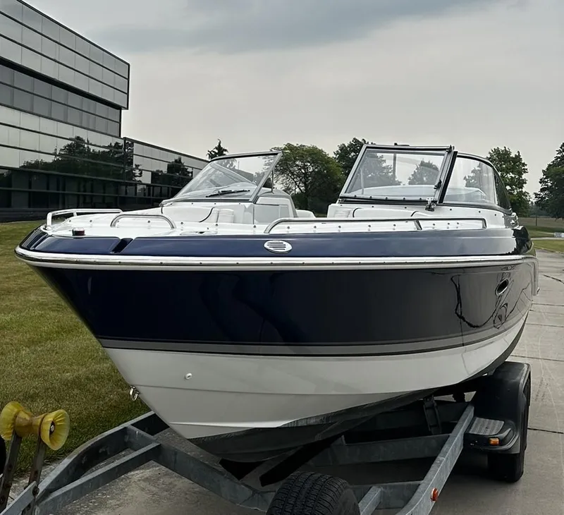 Slide: The Image of 2013 Formula 270 Bowrider boat on trailer, parked outdoors near modern building. - 3