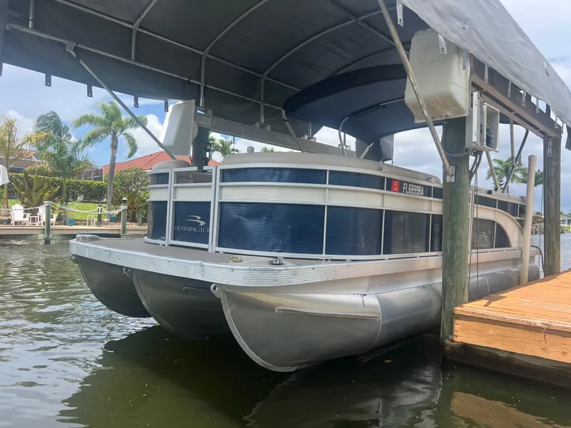 Slide: The Image of 2016 Bennington Sx pontoon boat docked under a canopy. - 0