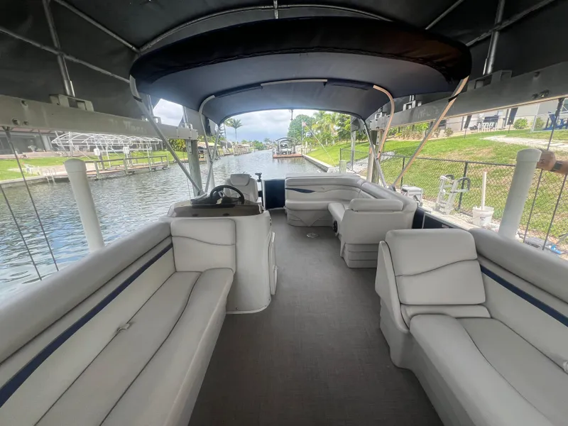 Slide: The Image of 2016 Bennington Sx pontoon boat with spacious seating and canopy on a calm waterway. - 10