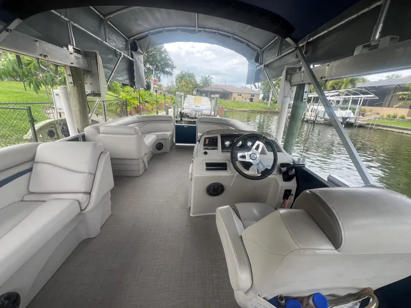 Slide: The Image of 2016 Bennington Sx pontoon boat interior with white seating and steering console. - 11