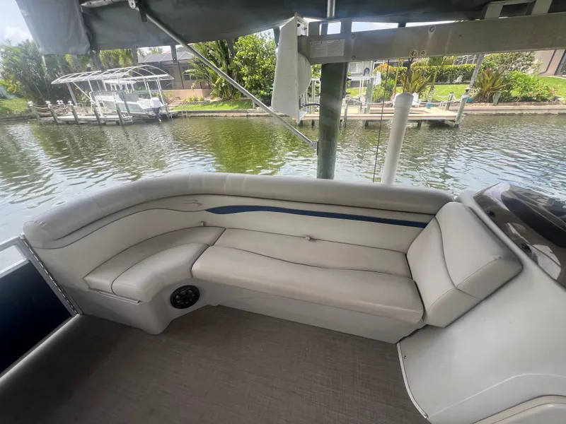 Slide: The Image of 2016 Bennington Sx boat interior with white seating by the water. - 18