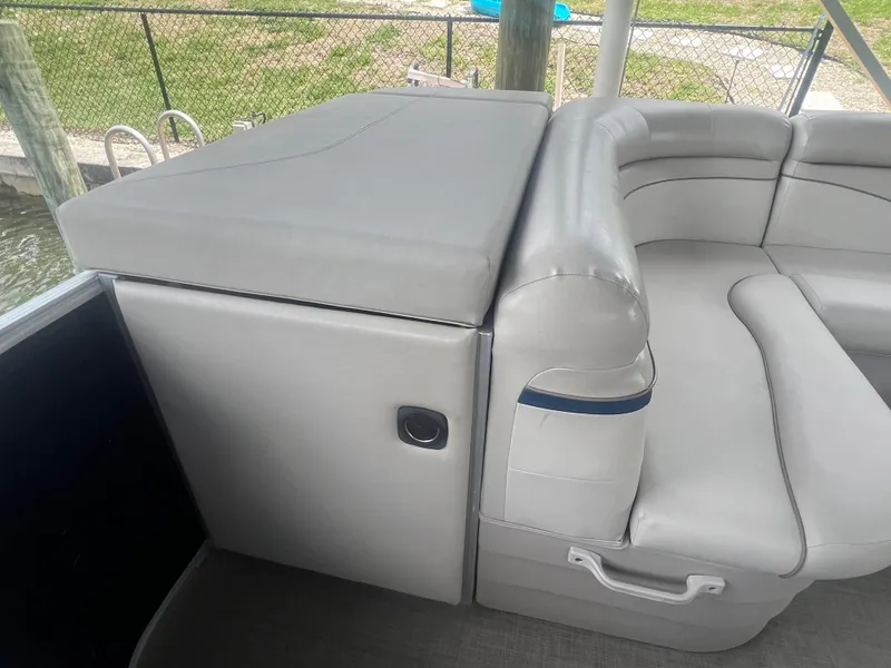 Slide: The Image of 2016 Bennington Sx boat interior with gray seating and storage compartment. - 21