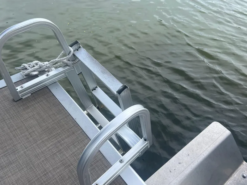 Slide: The Image of 2016 Bennington Sx boat ladder and deck by the water. - 24