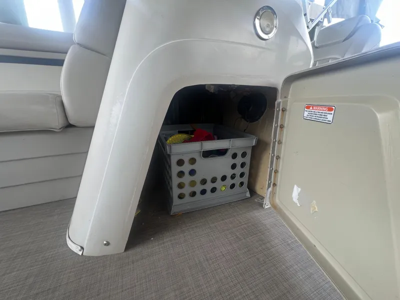 Slide: The Image of Storage compartment in a 2016 Bennington Sx boat with a plastic crate. - 27