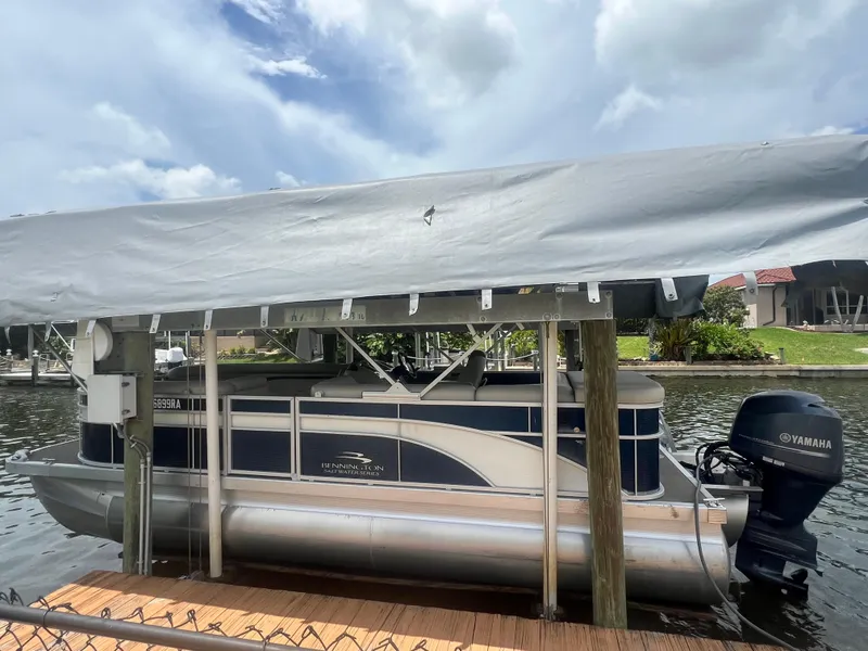 Slide: The Image of 2016 Bennington Sx pontoon boat docked under a canopy. - 3