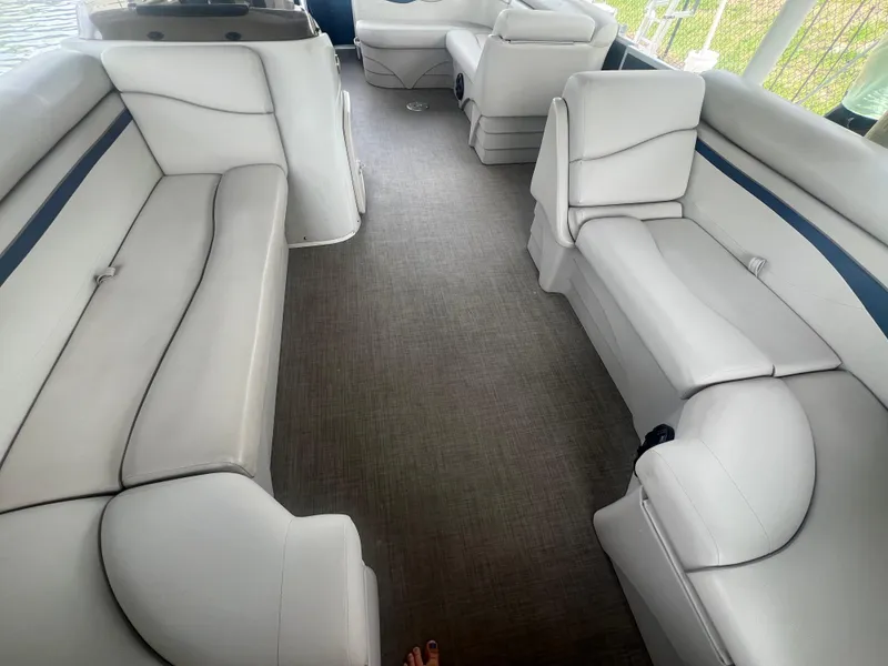 Slide: The Image of 2016 Bennington Sx boat interior with white cushioned seating and grey carpet. - 8