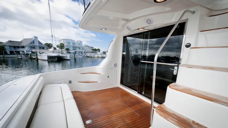 Slide: The Image of 2006 Sea Ray 58 Sedan Bridge yacht with wooden deck and marina view. - 9