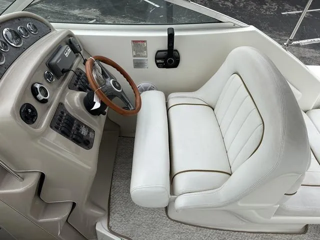 Slide: The Image of 1999 Sea Ray 270 Sundancer boat helm with steering wheel and captain's chair. - 10