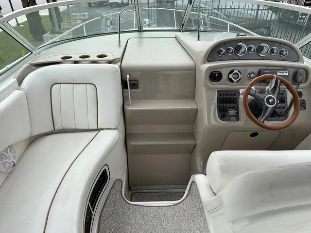 Slide: The Image of 1999 Sea Ray 270 Sundancer boat cockpit with steering wheel and seating. - 14