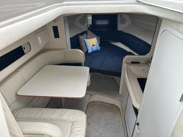 Slide: The Image of Interior cabin of 1999 Sea Ray 270 Sundancer with seating, table, and bed. - 15