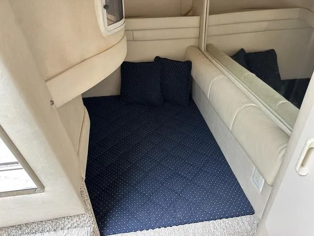 Slide: The Image of Interior cabin of 1999 Sea Ray 270 Sundancer with blue bedding and pillows. - 18