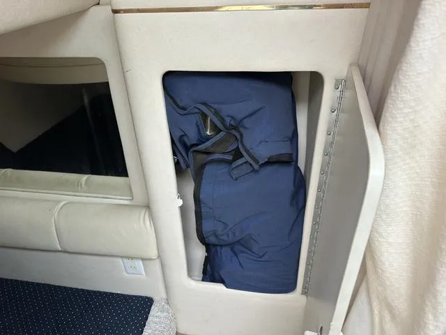 Slide: The Image of Storage compartment inside 1999 Sea Ray 270 Sundancer boat with blue bag. - 21