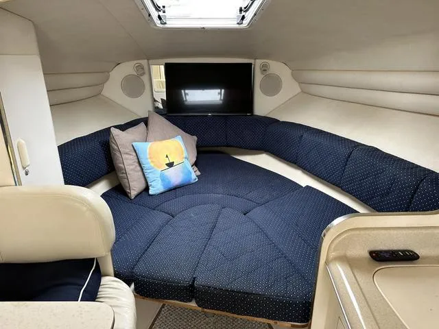 Slide: The Image of Interior cabin of a 1999 Sea Ray 270 Sundancer with blue seating and pillows. - 22