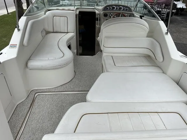Slide: The Image of 1999 Sea Ray 270 Sundancer boat interior with white seating and dashboard. - 8