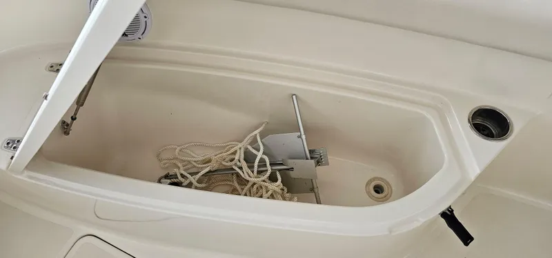 Slide: The Image of 2014 Pursuit C 260 Center Console anchor storage compartment with anchor and rope. - 13