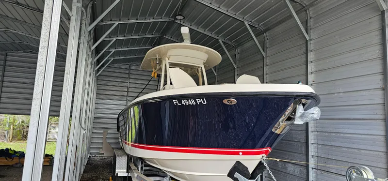 Slide: The Image of 2014 Pursuit C 260 Center Console boat in a metal storage shed. - 39