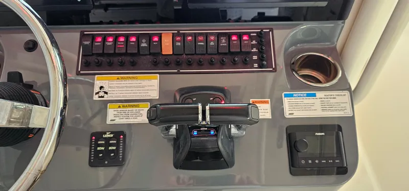 Slide: The Image of 2014 Pursuit C 260 Center Console boat dashboard with controls and switches. - 5