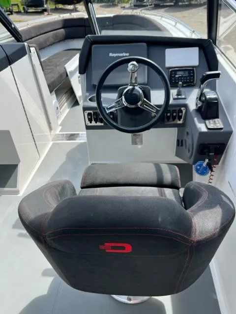Slide: The Image of Captain's seat and helm of a 2016 Draco 27 RS boat with modern controls. - 23